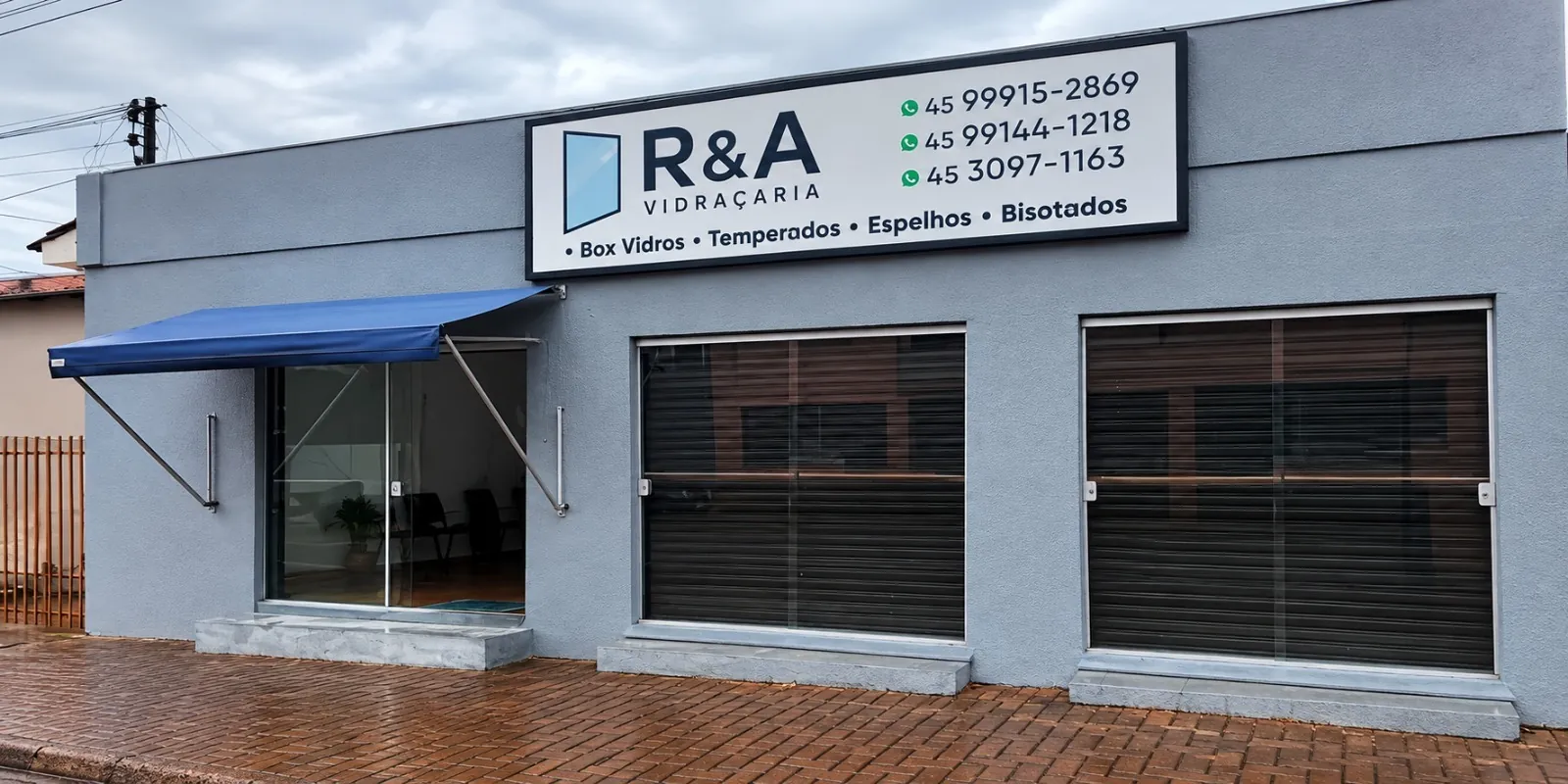 Fachada da R&A Vidraçaria em Cascavel, com toldo azul e placa